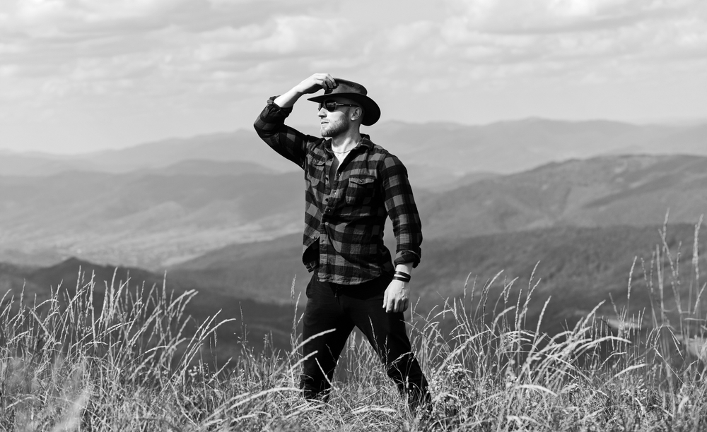 Ein Abenteurer mit einem Cowboy-Hut, den Blick zum Horizont gerichtet